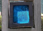 Holzgrabmal mit blauem Glas als Symbolik.