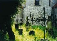 Transparenz: Historische eiserne Grabkreuze auf einem Kirchenfriedhof.