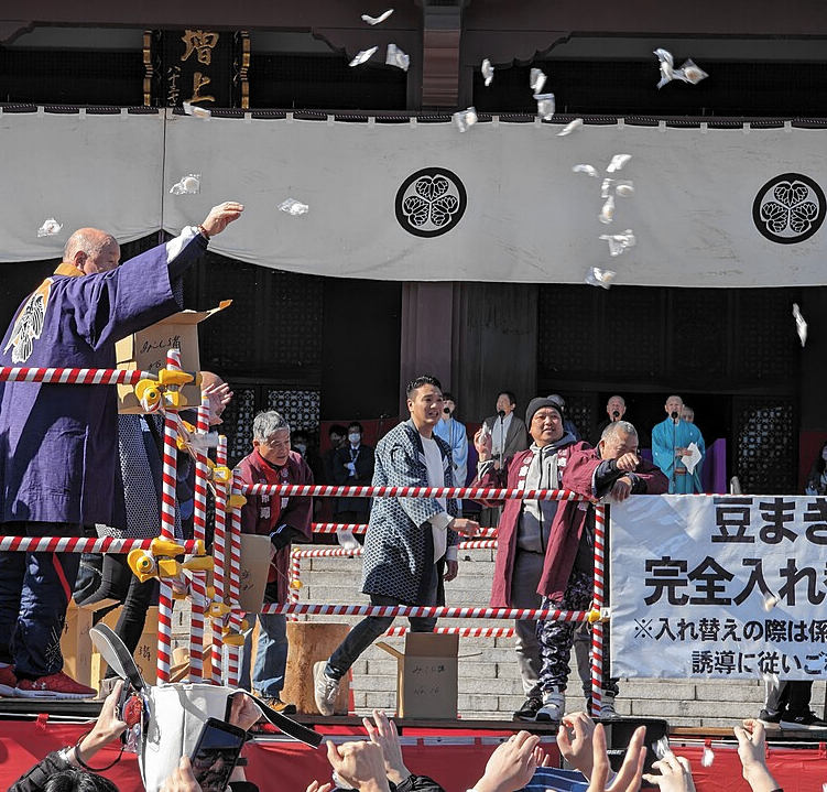 Ein Mönch verstreut Süßigkeiten zum Setsubun-Fest 