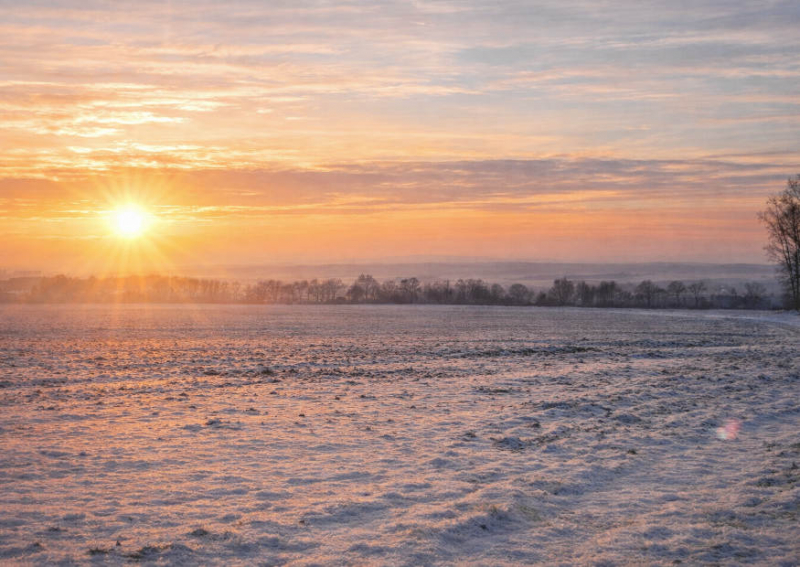 Weite Winterlandschaft und Sonnenuntergang