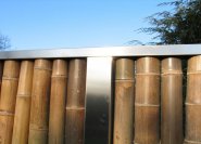 Moderner Sichtschutz aus Bambusrohr und Edelstahlrahmen.