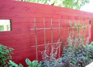 Trennwand im Garten, einfache Bretterwand mit farbigen Anstrich.