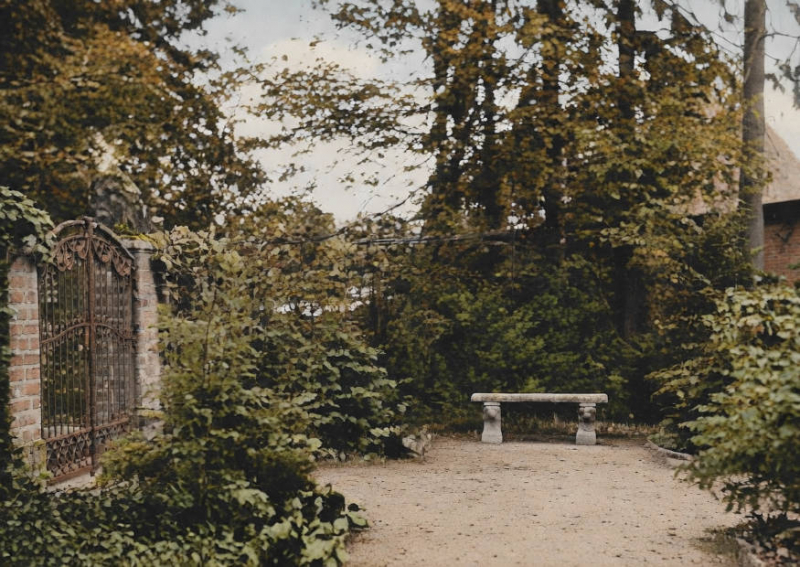 Gartenbank an einem großen Eisentor.