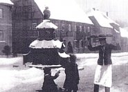 Ein Bäckergeselle mit Stollen vor dem Töpferbrunnen in Kohren-Sahlis (bei Gleithain). (Foto: K.Feuerriegel, 1928)
