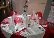 Festlich eingedeckter Tisch in rot, weiß und kristall.