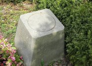 Kreissymbol auf einem kubischen Urnengrabmal. Dieses Urnendenkmal steht körperhaft auf der Grabfläche und ist kein Stein am Kopfende des Grabes ...