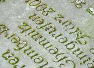 Bemooste Inschrift liegender Grabstein