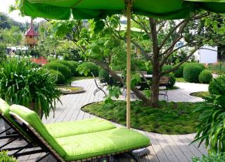 Moderner Garten mit Holzterrassierung und Liegestühlen