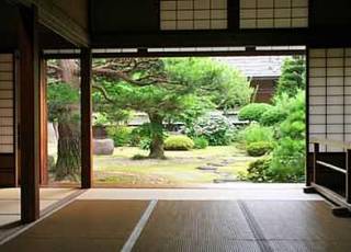 Japanischer Wohnraum mit offener Schiebetür zum Garten.