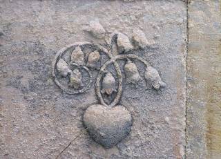 Symbol Herz mit Blumenranken auf einem Grabmal